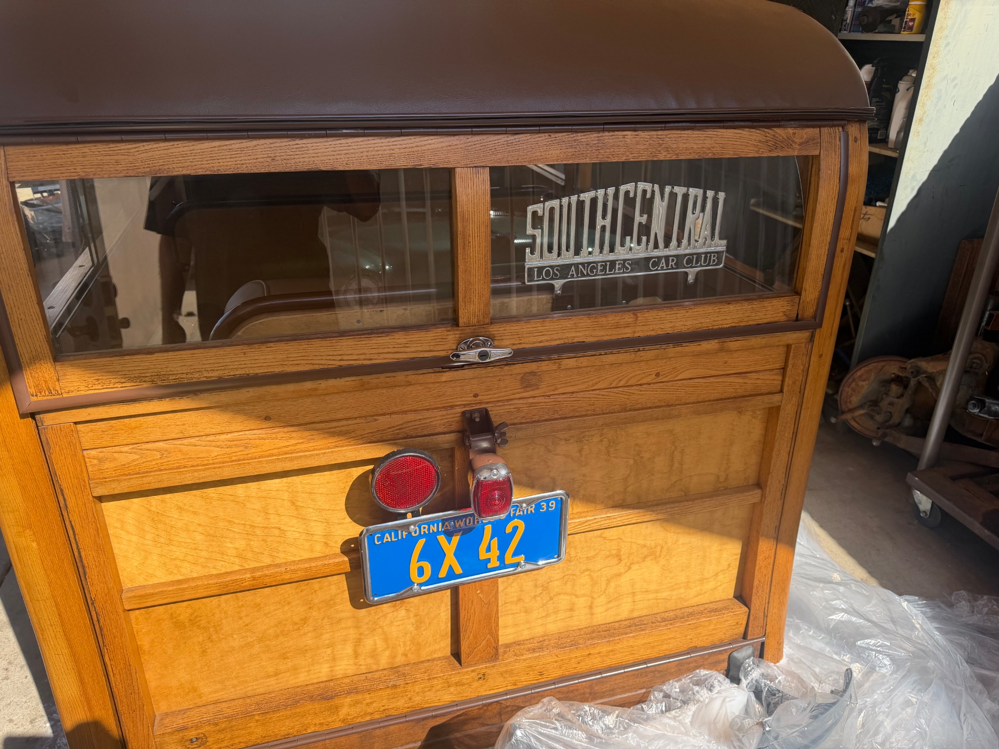 Rear detail of the club's woody with sign and license plate.